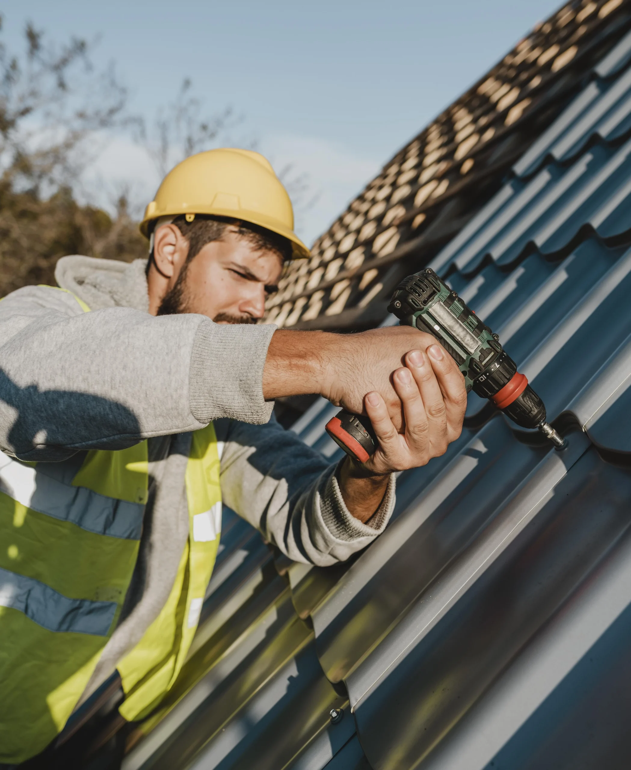 side view man working roof with drill